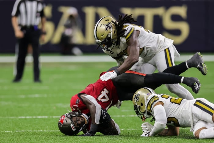 Tampa Bay receiver Chris Godwin (14) is tackled by New Orleans Saints cornerback Marshon Lattimore (23) and linebacker Demario Davis (56). Mandatory Credit: Stephen Lew-USA TODAY Sports
